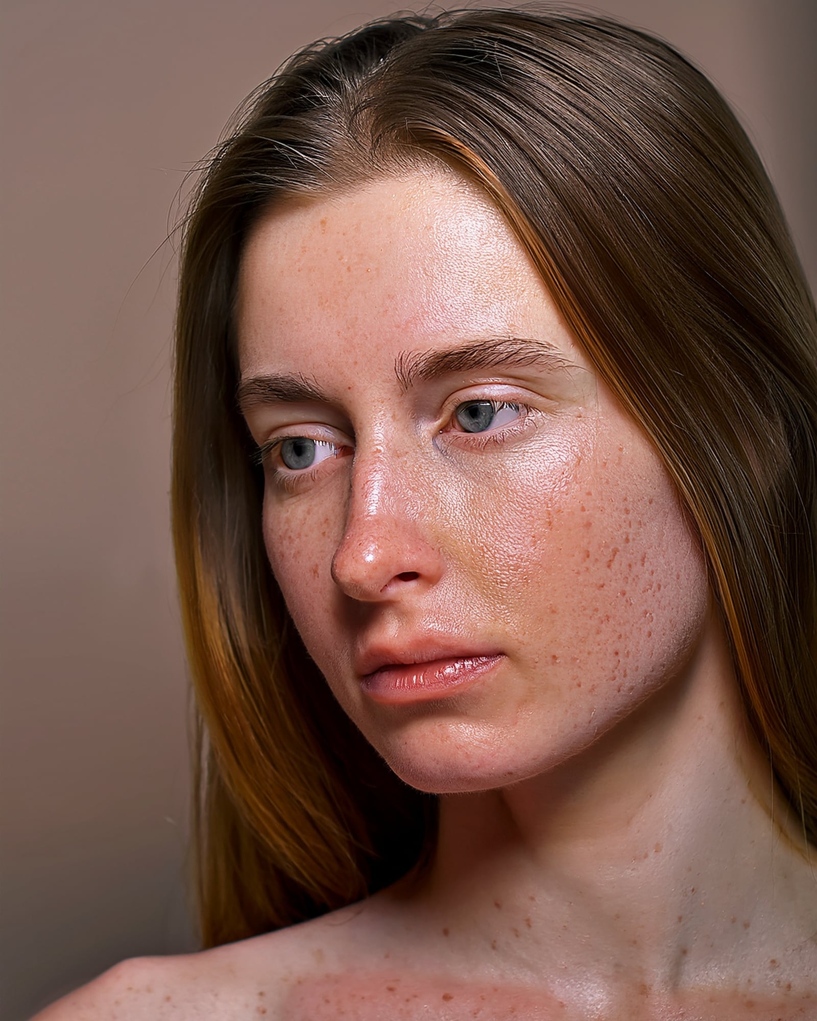 A woman photographed in flat daylight against plain plaster, her cheek showing uneven texture and faded blemish marks.